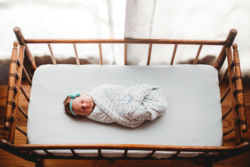 Atlanta Newborn Photographer, baby girl wrapped tightly in a blanket lays sleeping in crib