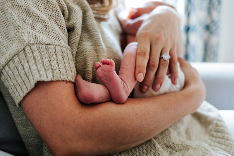 Atlanta Newborn Photographer, mother holds baby, tiny feet rest on arm