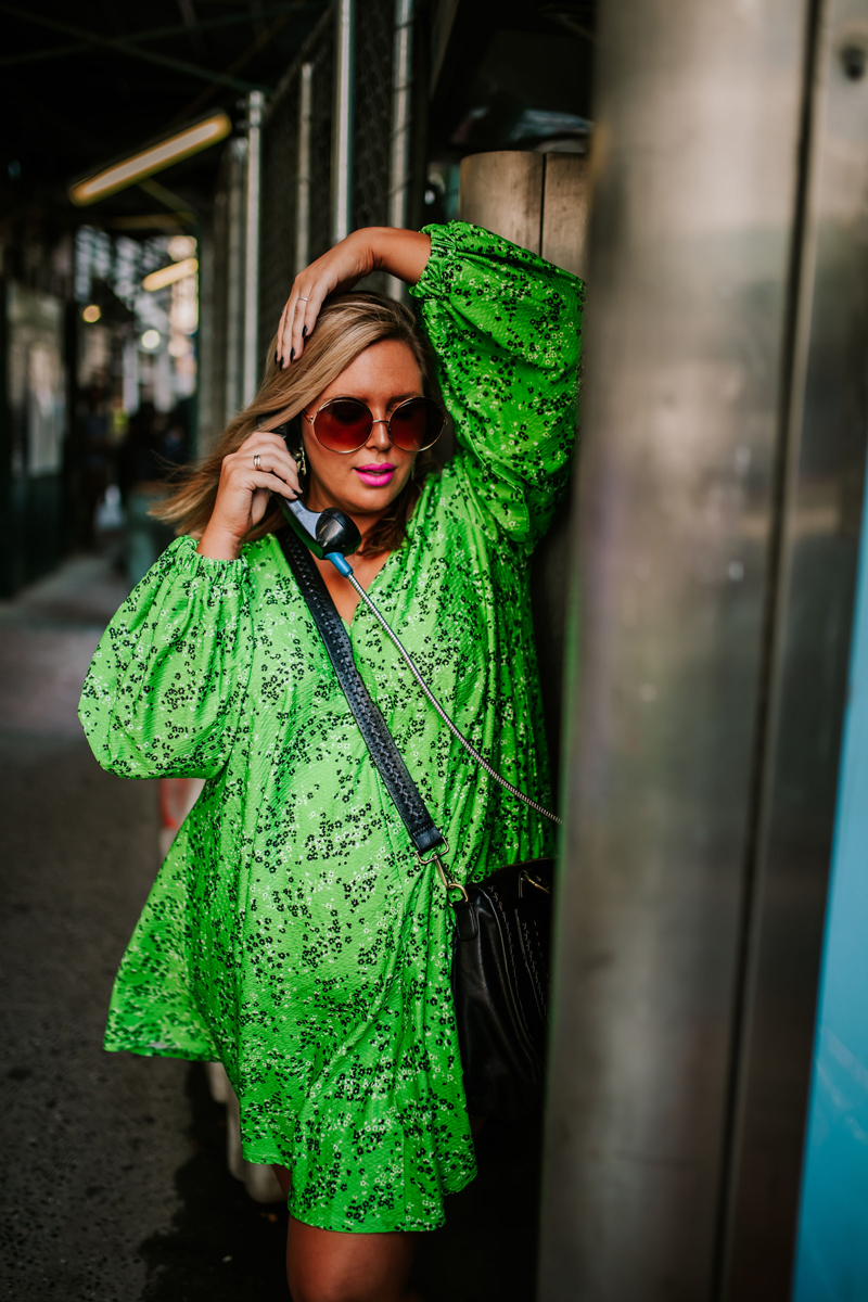 Atlanta Influencer-Blogger Photographer, woman talks on payphone with vibrant neon green dress