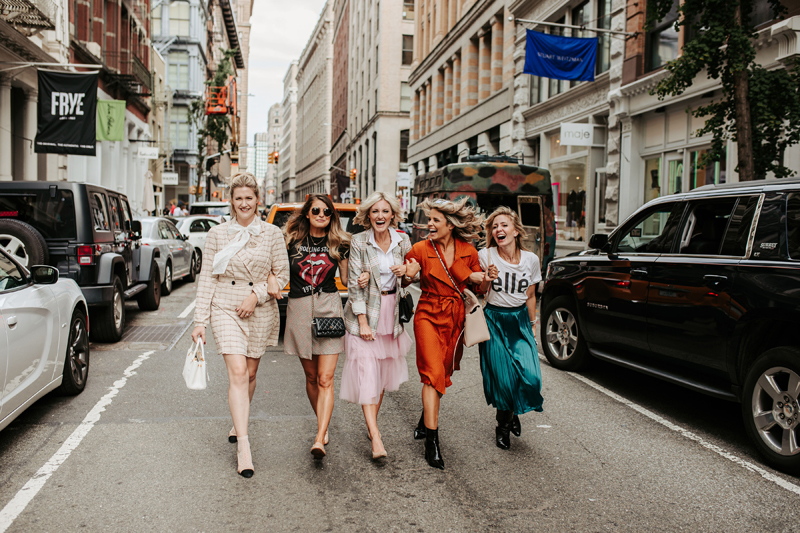 Atlanta Blogger-Influencer Photographer, five fashionably dressed women walk with arms locked downtown