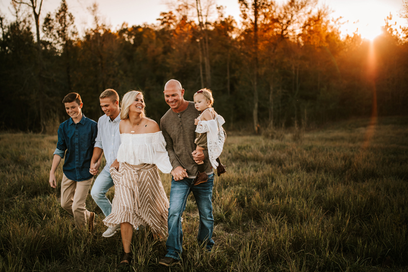 Atlanta Family Photographer, dad, mom, teenage sons, and baby daughter all walk back from the forest