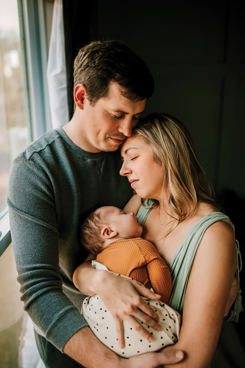 Atlanta Newborn Photographer, mom and dad hold each other close as baby rests in moms arms