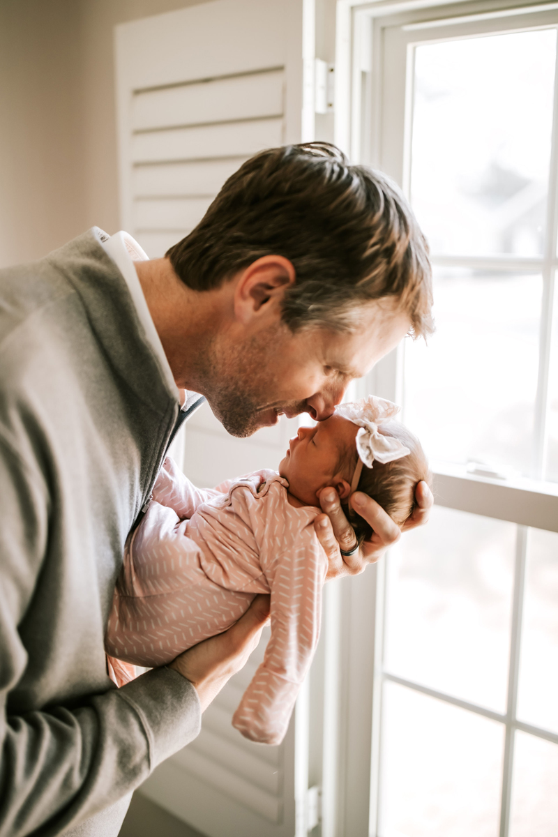 Atlanta Newborn Photographer, dad holds newborn daughter and presses nose to her forehead