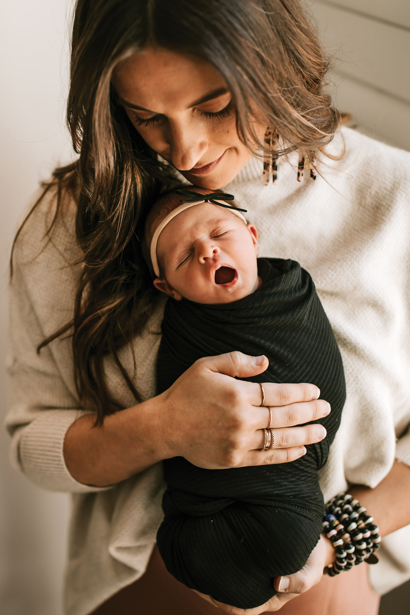 Atlanta Newborn Photographer, Happy mom holds newborn, baby lets out a cute little yawn
