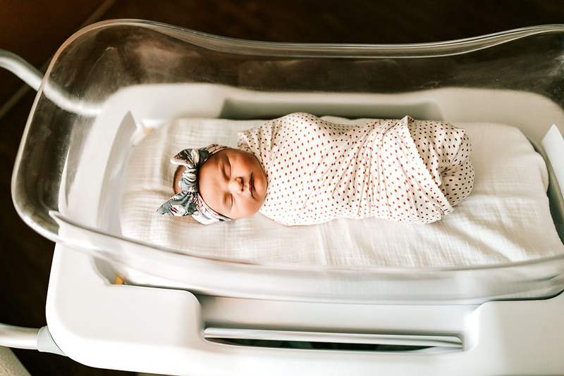 Atlanta Newborn Photographer, a baby is wrapped in blanket and sleeping cozily in bassinet