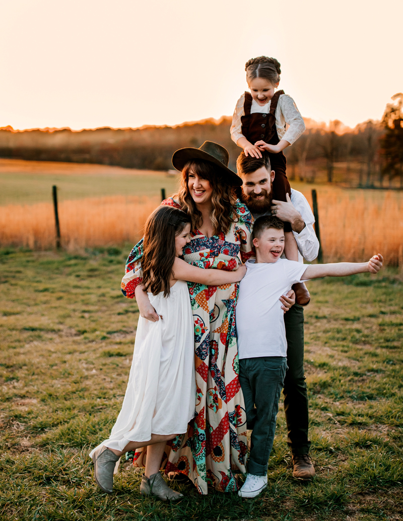 Atlanta Family Photographer, mom holds daughter and son, dad holds mom tight with other daughter on shoulders outside