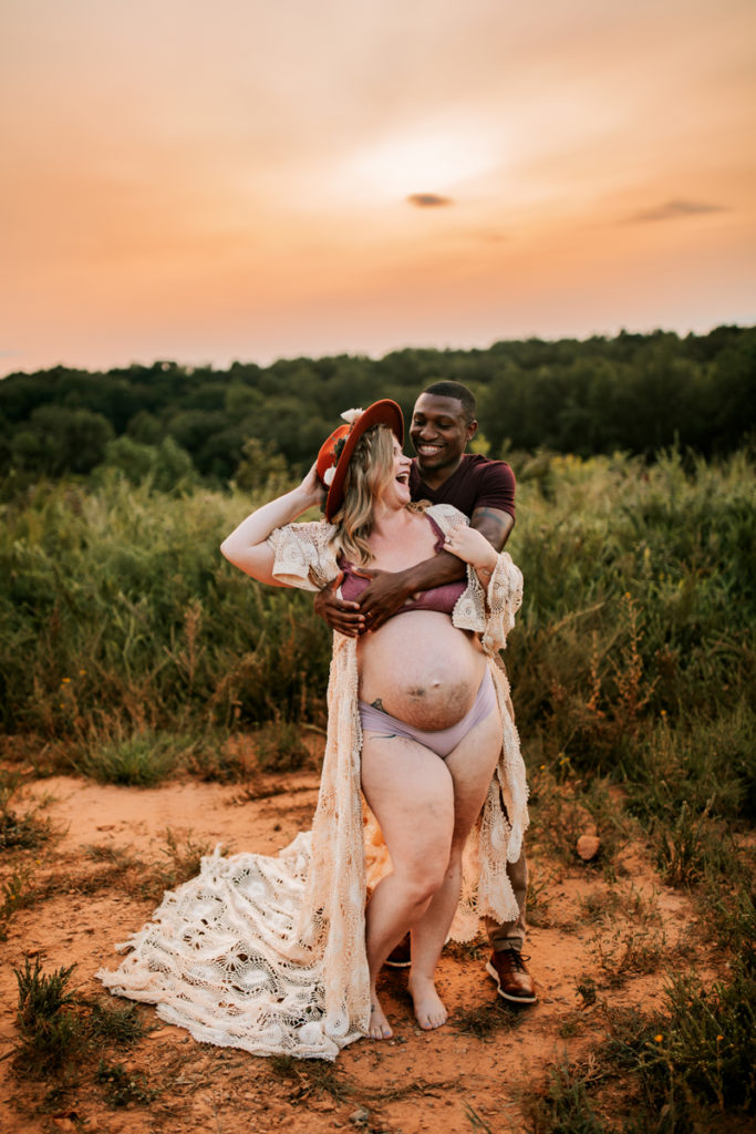 Photographer Mentorships, man and woman laughing together while she holds her pregnant belly