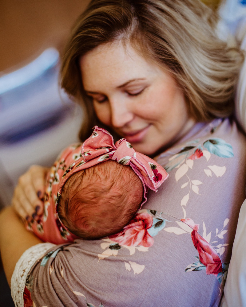 Atlanta Newborn Photographer, mother holds new baby, she wears floral kimono and baby has pink floral bow around head